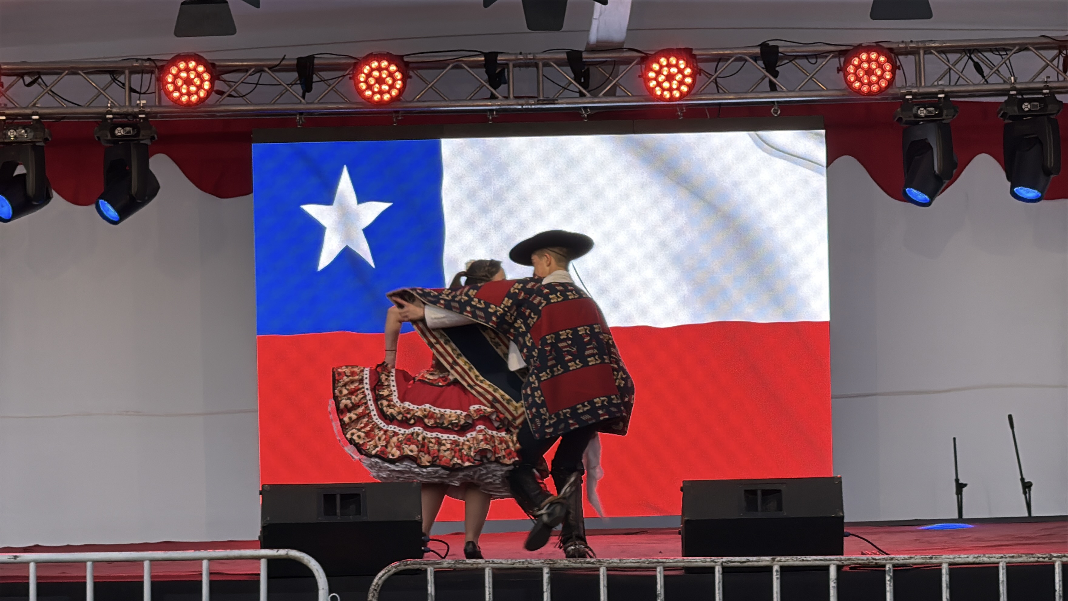 Pareja bailando cueca frente a pantalla LED y escenario con amplificaci&oacute;n FMusic